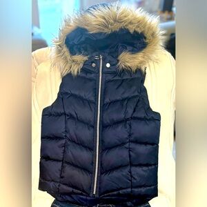 Padded vest in woven fabric with a detachable, fluffy-trimmed hood.